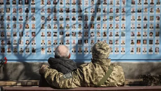 Two people visit the Wall of Remembrance in Kyiv