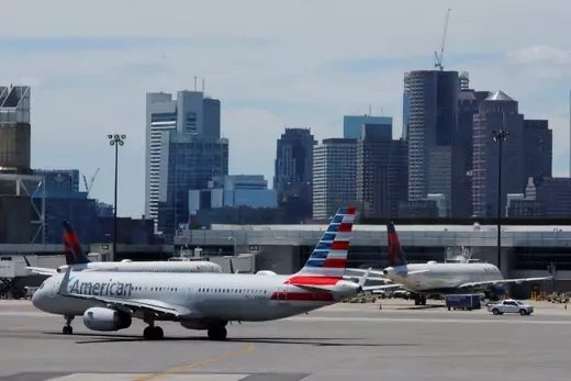 A American Airlines plane taxis in front of the skyline at Logan Airport at the start of the long July 4th holiday weekend in Boston, Massachusetts.