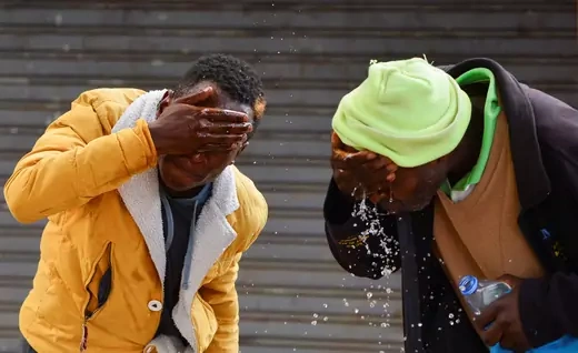 Two protesters in Kenya wash their face from teargas after clashing with riot police in Nairobi, Kenya.