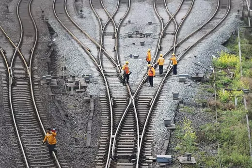 Workers inspect railway tracks, which serve as a part of the Belt and Road freight rail route linking Chongqing to Duisburg.