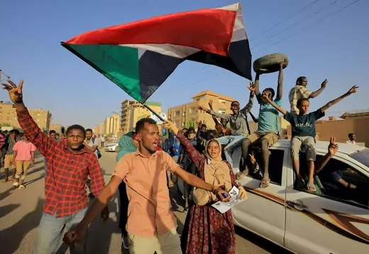 Protesters holding a Sudanese flag march during a rally marking the anniversary of the April uprising, in Khartoum, Sudan.