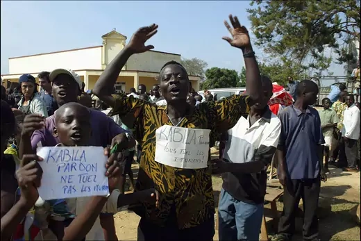 Militia members holding up signs protest against Kabila’s government.