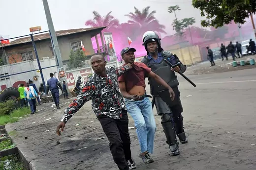 Security forces in Kinshasa arrest a demonstrator during protests against a new electoral law.