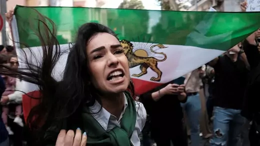woman in front of flag at protest against iranian government
