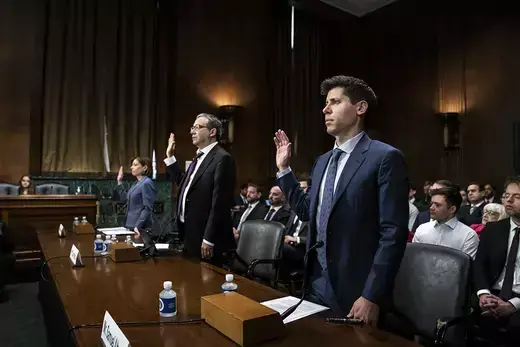 At a Senate Judiciary subcommittee hearing, three witnesses hold up their hands as they are sworn in to testify on rules for artificial intelligence.