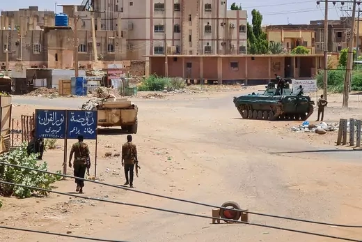 Soldiers from the Sudanese Armed Forces walk near armored vehicles in Khartoum, Sudan.