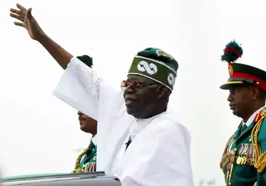 Nigeria's President Bola Tinubu waves to a crowd on a vehicle after his inauguration as president.