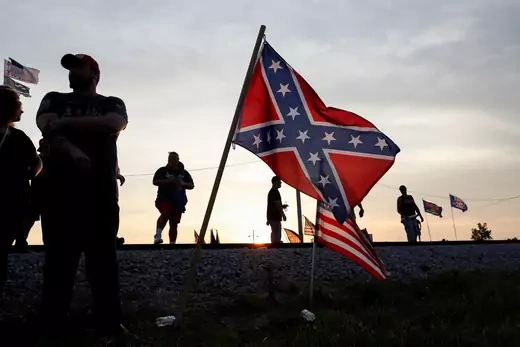 Supporters of former U.S. President Donald Trump stand near Confederate and U.S. flags in Wellington, Ohio on June 26, 2021.