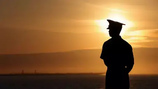 US marine looking at sunset by coast