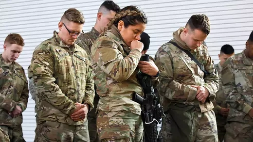 U.S. soldiers bow their heads in prayer