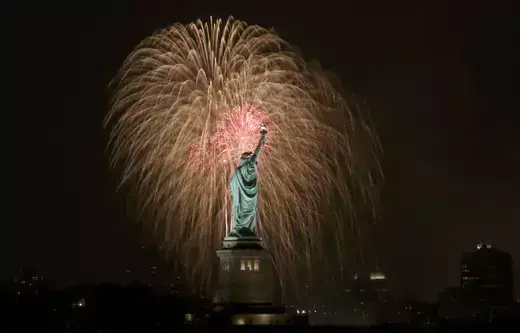 New York City fireworks light up the sky over the Statue of Liberty.