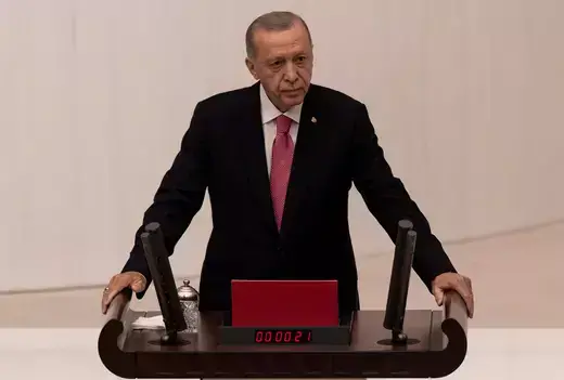 Erdogan as viewed standing at a podium before parliament. 