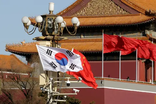 A South Korean flag and several Chinese flags flutter next to Tiananmen Gate in Beijing