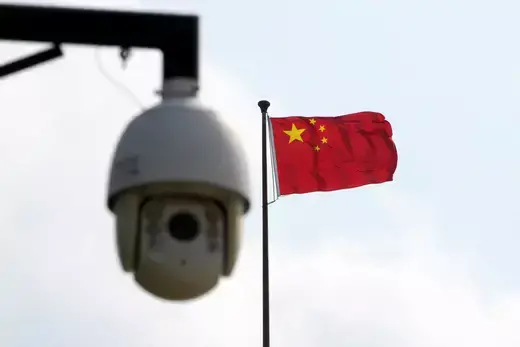 A surveillance camera is seen near a Chinese flag in Shanghai, China.