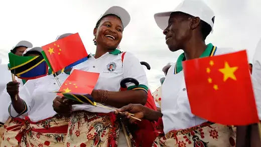 Tanzanian women holding red Chinese flags at Dar es Salaam.