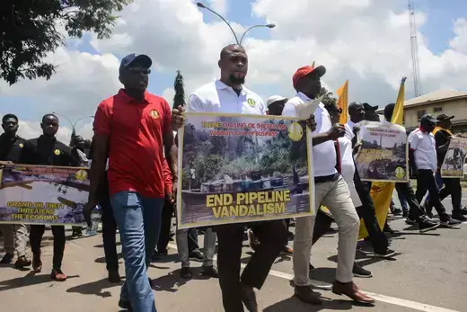 Members of the Petroleum and Natural Gas Senior Staff Association of Nigeria (PENGASAN), walk with signs during a protest over crude oil theft.