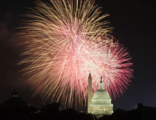 Fireworks as viewed exploding over the United States Capitol dome and Washington Monument at night.