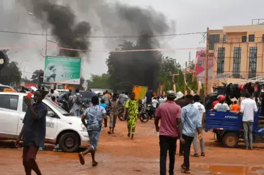 A general view of billowing smoke can be seen alongside supporters of the Nigerien defense and security forces attacking the headquarters of the Nigerien Party for Democracy and Socialism (PNDS).
