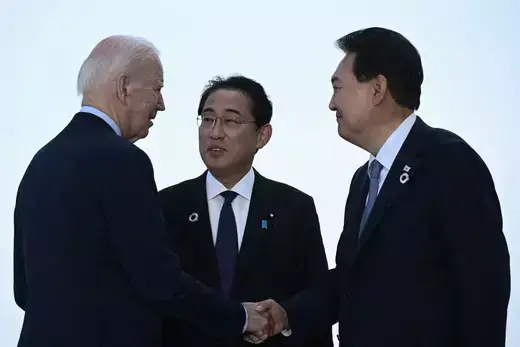 U.S. President Joe Biden, Japan's Prime Minister Kishida Fumio, and South Korea's President Yoon Suk Yeol greet each other ahead of a trilateral meeting during the G7 Leaders' Summit in Hiroshima on May 21, 2023. 