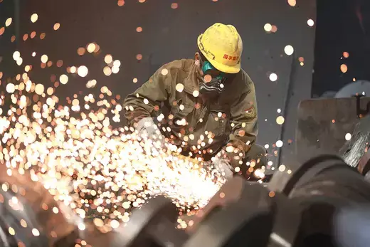 A worker as viewed metals as sparks fly.