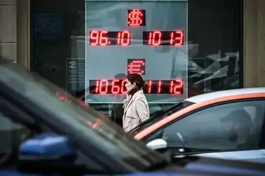 A woman walks past a currency exchange office in Moscow.
