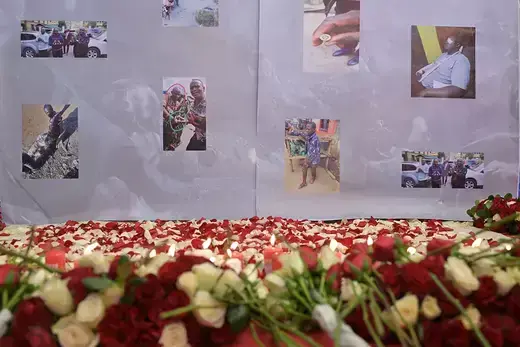 Red and white flowers lay before a vigil of photos showing Kenyans who had been killed in recent protests in July 2023 in Nairobi, Kenya.