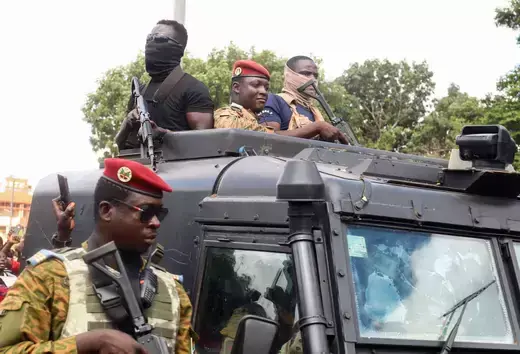 Burkina Faso's self-declared new leader Ibrahim Traore is pictured in an armored vehicle protected by men holding rifles.