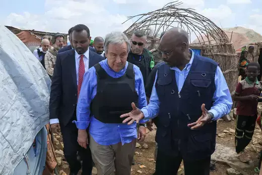UN Secretary-General António Guterres is escorted by staff at a displaced persons camp in Somalia.