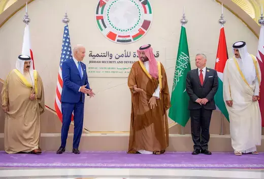 US President Joe Biden stands to the left of Saudi Crown Prince Mohammed bin Salman as they gather to take a photo with their nations' flags.