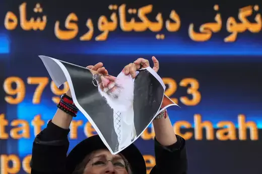 Iranian singer Gissoo Shakeri tears pictures of Iran's Supreme Leader Ayatollah Ali Khamenei as Iranian community members and supporters of the National Council of Iran take part in a protest in solidarity with Iranian people, in Paris, France on February 12, 2023.