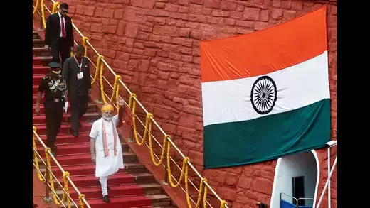 Indian Prime Minister Modi walking down steps. 