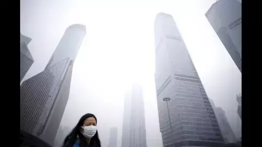 City buildings and a woman wearing a protective mask.