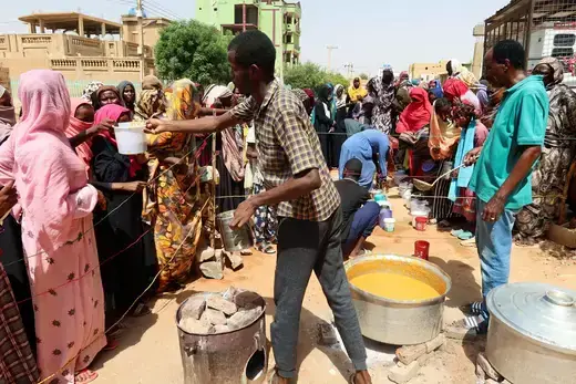 A volunteer distributes food to people in Omdurman, Sudan on September 3, 2023. 