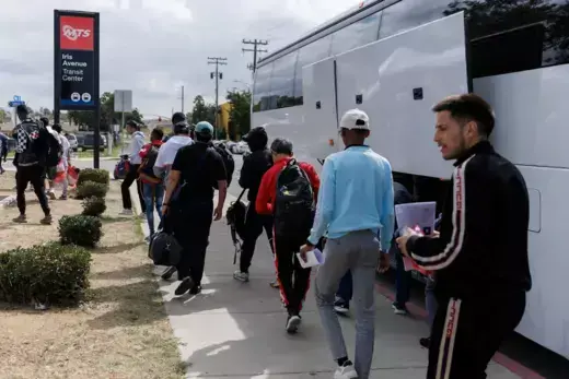 After processing by U.S. Immigration, migrants are dropped off by a bus at a transit center to continue their journey in the United States from San Diego, California.