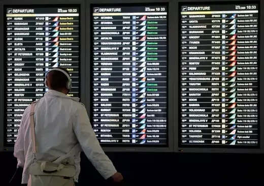 A man looks at a flight information board at the departure zone of Vnukovo International Airport in Moscow, Russia.