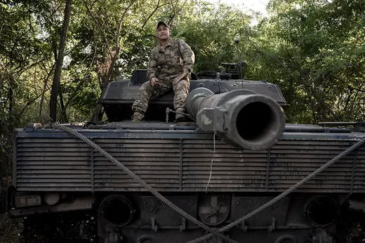 A Ukrainian soldier sits on a German-made Leopard tank.