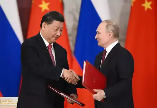 Chinese President Xi Jinping shakes hands with Russian President Vladimir Putin.