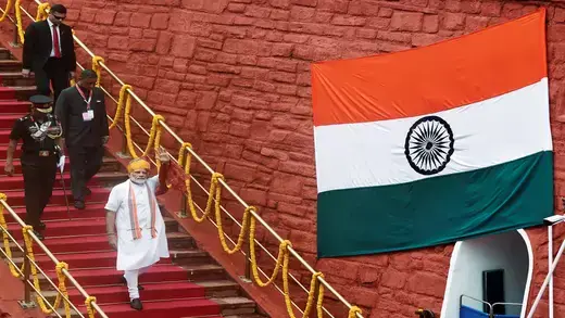Indian Prime Minister Modi walking down steps. 