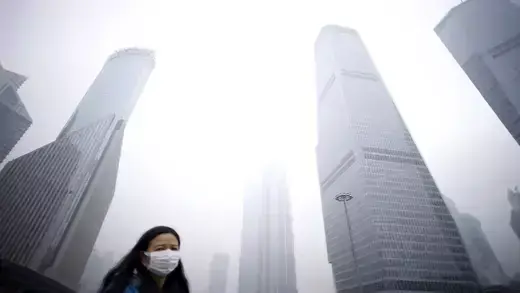 City buildings and a woman wearing a protective mask.