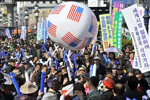 South Korean conservative activists raise a banner reading “let’s occupy the world market and become an economic power,”.