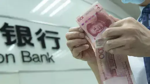 A bank employee counts Chinese Yuan.