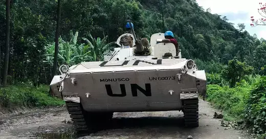 A peacekeeping vehicle transports troops on a dirt road in the DRC. 