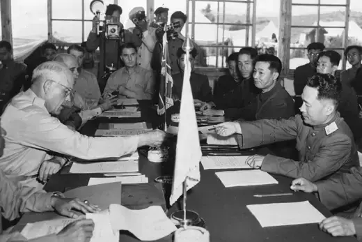 Maj. Gen. Blackshear M. Bryan exchanges credentials with Communist Lt. Gen. Lee Sang Cho at the opening session of the Military Armistice Commission at the Panmunjom Conference House on July 27, 1953.