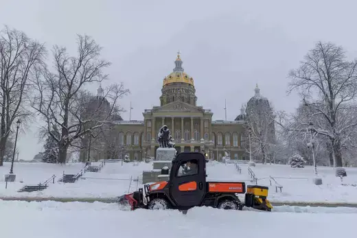 A snow truck as viewed clearing snow in front of the State Capitol Building in Iowa.