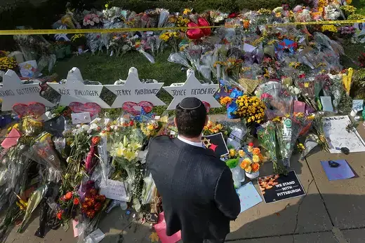 A Jewish man prays at a makeshift memorial of flowers and handwritten notes outside the Tree of Life synagogue in Pittsburgh.