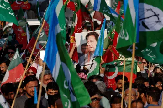 A portrait of the former Prime Minister Imran Khan is seen amid flags of Pakistan Tehreek-e-Insaf (PTI) and the religious and political party Jamat-e-Islami (JI) as supporters attend a joint protest demanding free and fair results of the elections, outside the provincial election commission of Pakistan (ECP)in Karachi, Pakistan on February 10, 2024.