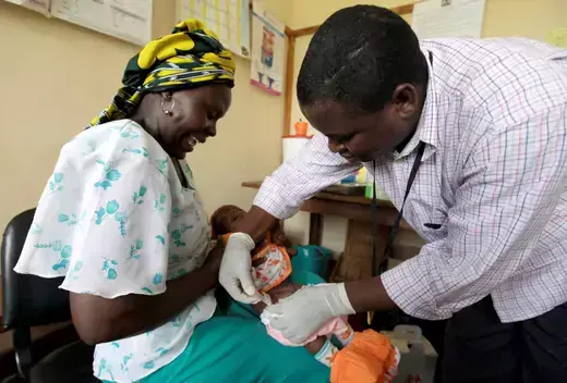 Iren Salama holds her baby Pendo as it is given an injection as part of a malaria vaccine trial at a clinic in the Kenya coastal town of Kilifi on November 23, 2010