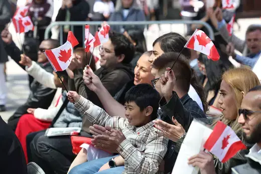 New Canadians wave the national flag during a citizenship ceremony in Toronto.