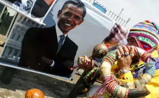 A shaman performs a ritual in front of a photograph of President Barack Obama in Lima