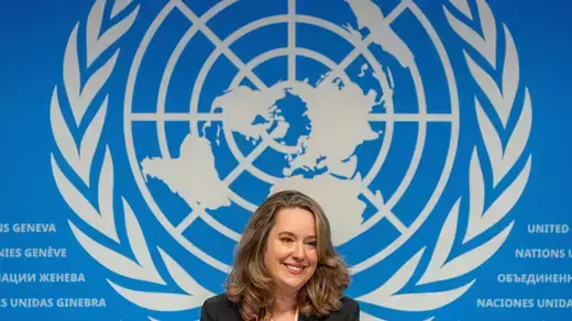 Amy Pope, the new Director General of the International Organization of Migration sitting against the backdrop of United Nations logo.